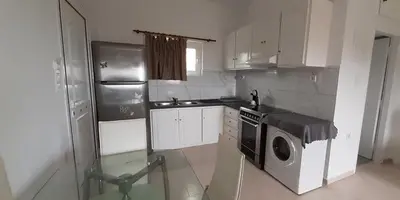 a kitchen with a refrigerator and a washing machine at Thea Apartment in Agia Marina Nea Kydonias
