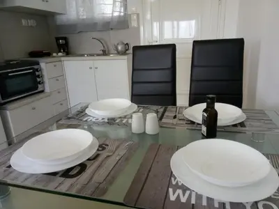 a kitchen with a table with white plates on it at Thea Apartment in Agia Marina Nea Kydonias