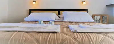 a bed with towels and two candles on it at Thea Apartment in Agia Marina Nea Kydonias