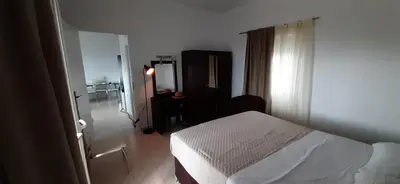 a bedroom with a white bed and a mirror at Thea Apartment in Agia Marina Nea Kydonias