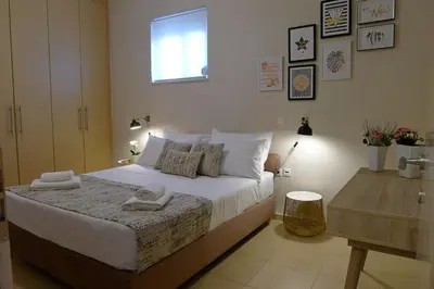 a bedroom with a bed with towels on it at Maria & Manos Guest House, Agios Onoufrios beach in Agios Onoufrios