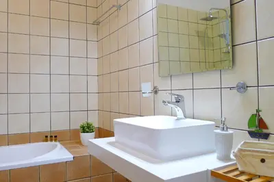 a bathroom with a white sink and a mirror at Maria & Manos Guest House, Agios Onoufrios beach in Agios Onoufrios