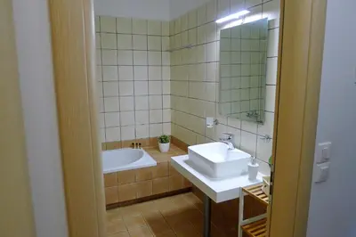 a bathroom with a sink and a tub and a mirror at Maria & Manos Guest House, Agios Onoufrios beach in Agios Onoufrios