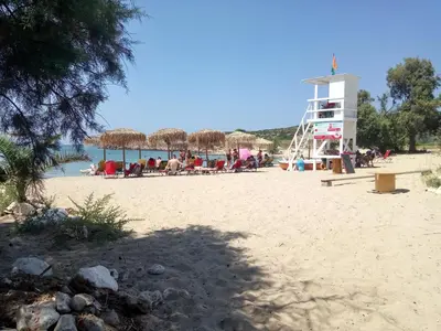 a group of people on a beach with a lifeguard tower at Maria & Manos Guest House, Agios Onoufrios beach in Agios Onoufrios