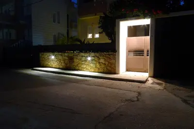 a white door with a light on the side of a building at Maria & Manos Guest House, Agios Onoufrios beach in Agios Onoufrios