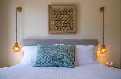 a bed with two lights and a picture on the wall at Gianthea Studios and Apt in Stalos