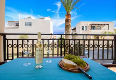a table with a bottle of wine and wine glasses at Gianthea Studios and Apt in Stalos
