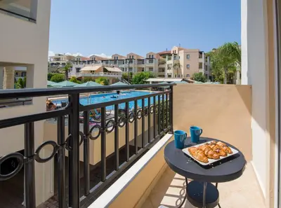 a table with a tray of pastries on a balcony at Gianthea Studios and Apt in Stalos