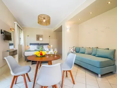 a living room with a couch and a table at Gianthea Studios and Apt in Stalos