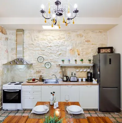 a kitchen with white cabinets and a stainless steel refrigerator at Michalis Stonehouse in Chania Town