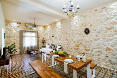 a living room with a table and a stone wall at Michalis Stonehouse in Chania Town