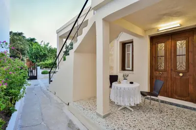 a house with a table and chairs on the porch at Michalis Stonehouse in Chania Town