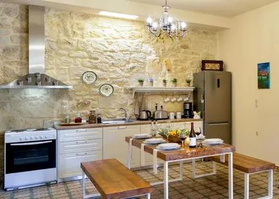 a kitchen with a table and a refrigerator at Michalis Stonehouse in Chania Town
