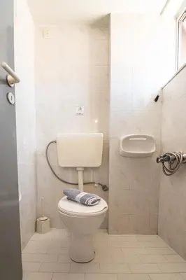 a bathroom with a white toilet and a sink at Girogiali beach hotel - Adults only in Stalos