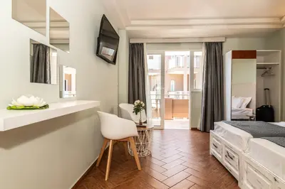 a bedroom with a bed and a desk and a chair at Girogiali beach hotel - Adults only in Stalos