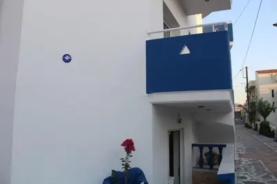 a blue sign on the side of a white building at Bay View Apartments in Plataniás