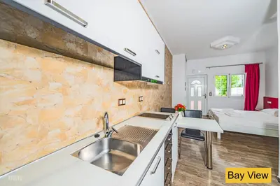 a kitchen with a sink and a bed in a room at Bay View Apartments in Plataniás