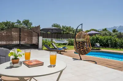 a patio with a table and two glasses of orange juice at Villa Aphrodite in Alikianós