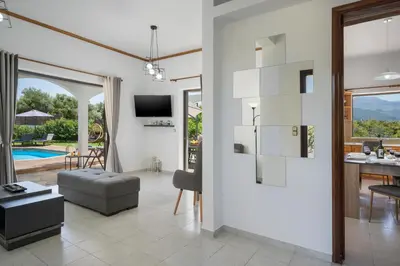 a living room with a view of a pool at Villa Aphrodite in Alikianós