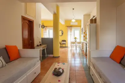 a living room with two couches and a table at Evelia Apartment in Galatás