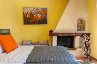 a bedroom with a bed and a fireplace at Evelia Apartment in Galatás