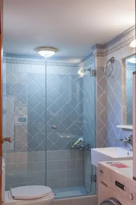 a bathroom with a shower with a toilet and a sink at Evelia Apartment in Galatás
