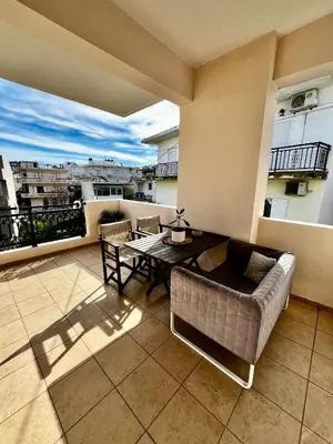 a living room with a couch and a table on a balcony at Tzitzifianaki Cozy Apartment in Chania Town