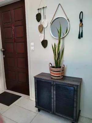 a mirror and a potted plant on a cabinet in a hallway at Tzitzifianaki Cozy Apartment in Chania Town