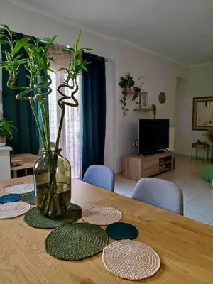 a wooden table with a vase with plants in it at Tzitzifianaki Cozy Apartment in Chania Town