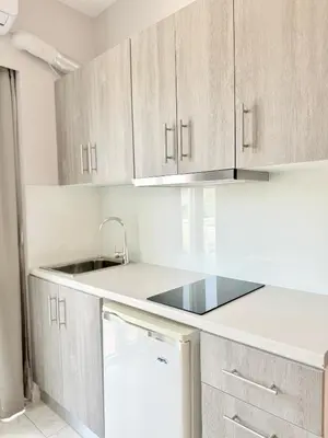 a kitchen with wooden cabinets and a sink at Avenue Hotel Falassarna in Falasarna