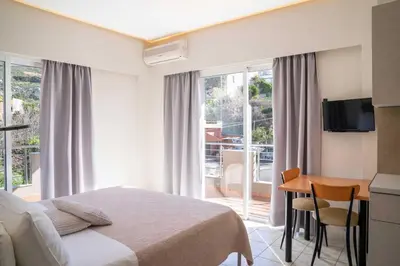 a bedroom with a bed and a desk with a television at Avenue Hotel Falassarna in Falasarna