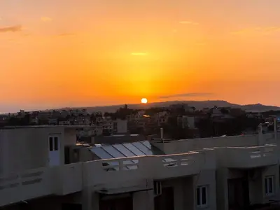 a sunset from the roof of a building with the sun setting at Eloque Simple living space in Kato Daratso