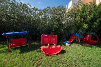 a group of childrens play equipment in the grass at Socrates Holidays Apt 4 with Pool near the Beach in Kamisianá