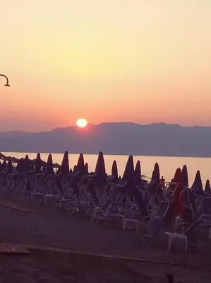 a group of chairs on the beach at sunset at Villa Giorgos in Plataniás