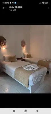 a bedroom with two beds and two lights on the wall at Villa Giorgos in Plataniás