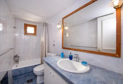 a bathroom with a sink and a toilet and a mirror at Ismini Apartments in Kalyves