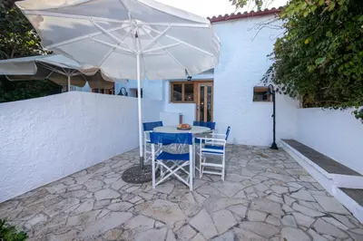 a table and chairs under an umbrella on a patio at Ismini Apartments in Kalyves