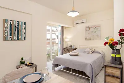 a bedroom with a bed and a table and a chair at Melina Apartments in Chania Town