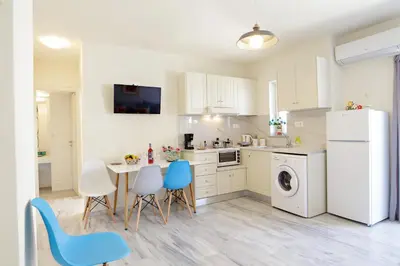 a kitchen with a table and chairs and a white refrigerator at Melina Apartments in Chania Town