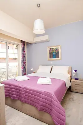 a bedroom with a large bed with a purple blanket at Melina Apartments in Chania Town