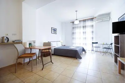 a bedroom with a bed and a table and a dining room at Cozy Studio Chania in Chania Town