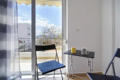 a small table and chairs in a room with a window at Cozy Studio Chania in Chania Town