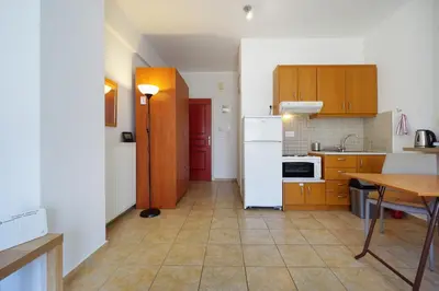a kitchen with a white refrigerator and a table at Cozy Studio Chania in Chania Town
