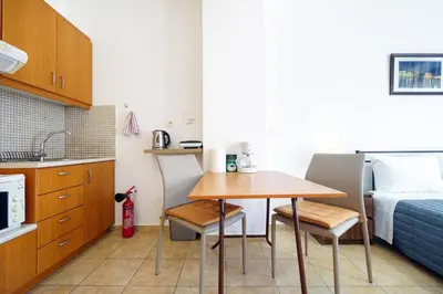 a small kitchen with a table and a bed at Cozy Studio Chania in Chania Town