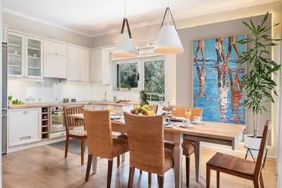 a kitchen with a dining room table and chairs at Anemone Holiday Apartment in Kato Daratso