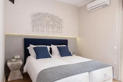a bedroom with a large white bed with blue pillows at Anemone Holiday Apartment in Kato Daratso