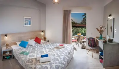 a bedroom with a bed and a table with chairs at Argo Apartments in Kato Daratso