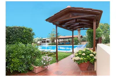 a wooden pergola next to a swimming pool at Argo Apartments in Kato Daratso