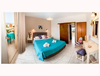 a bedroom with a blue bed with two pillows on it at Argo Apartments in Kato Daratso