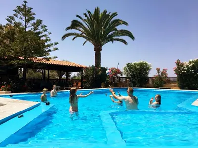 a group of people in a swimming pool at Argo Apartments in Kato Daratso